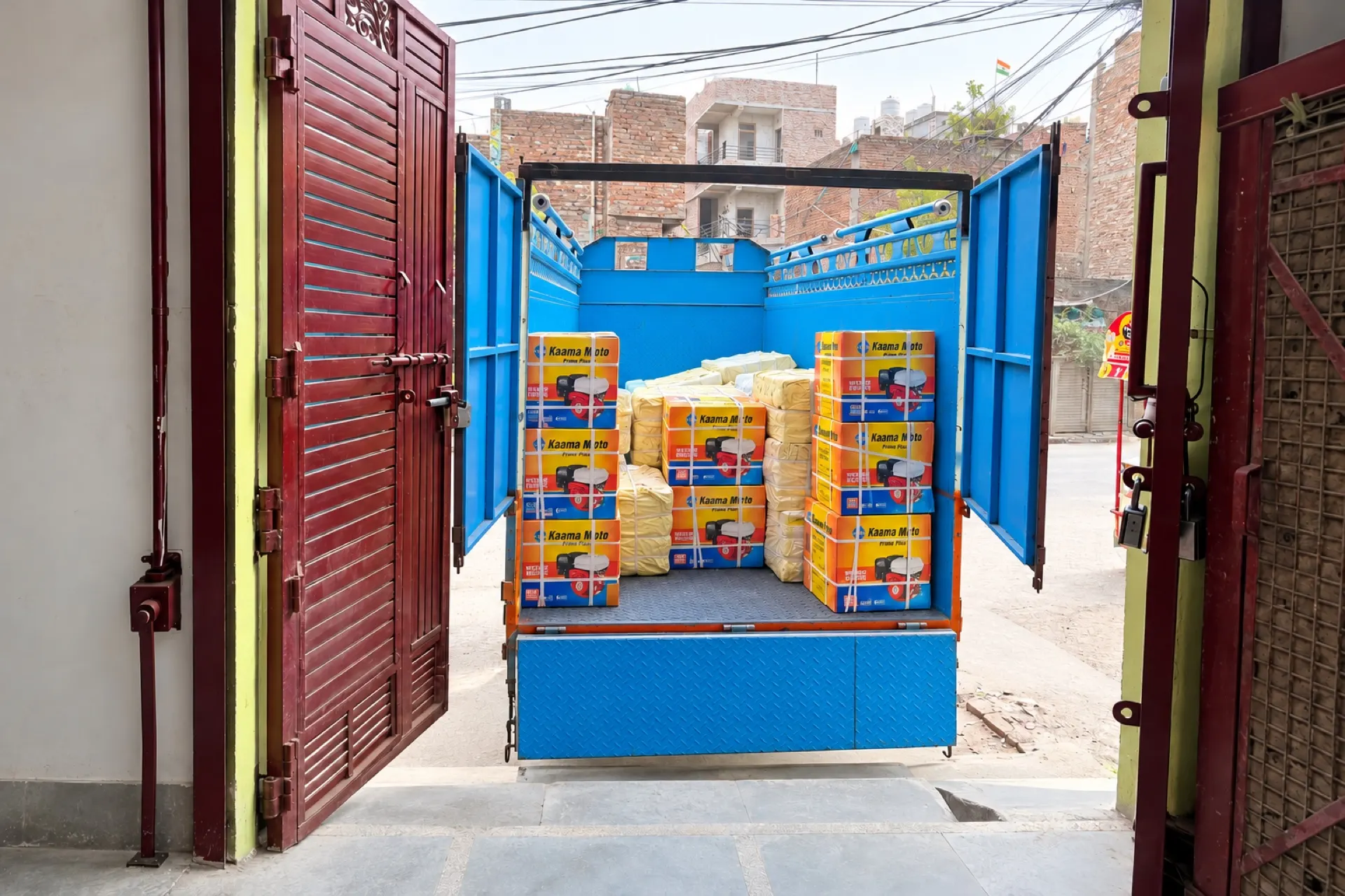 A truck at the godown door, loaded with Kaama Moto cartons